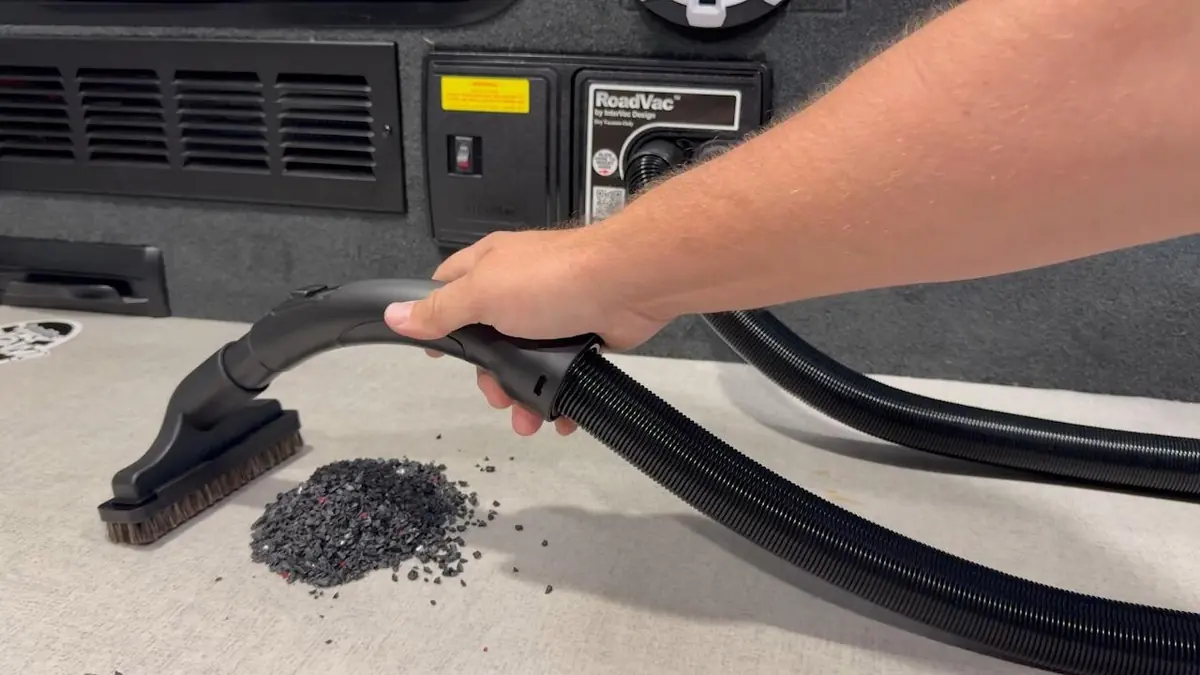 A RoadVac front panel with the hose in use inside an RV