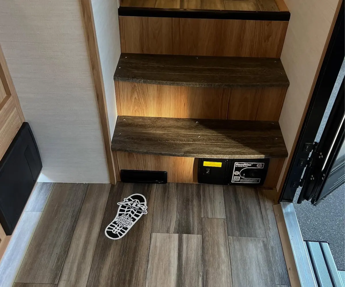 A VacPort sweep inlet installed at floor level in a coach